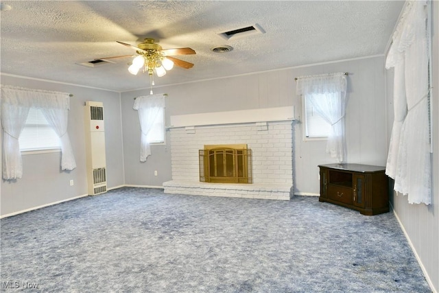 unfurnished living room featuring carpet floors, a fireplace, a ceiling fan, visible vents, and crown molding