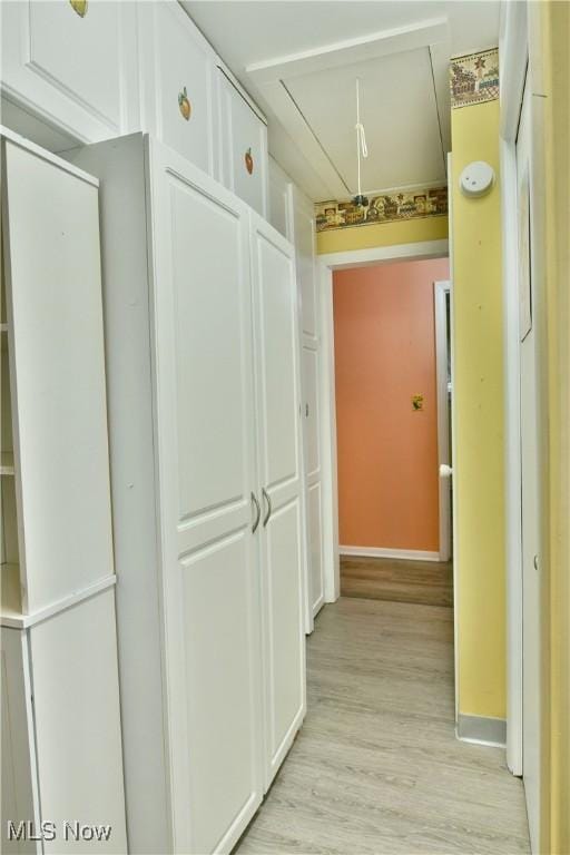 corridor featuring attic access and light wood-style floors