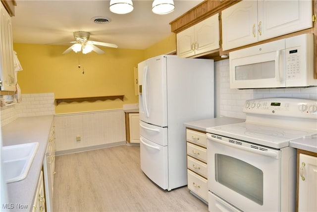 kitchen featuring white appliances, visible vents, light countertops, and a sink