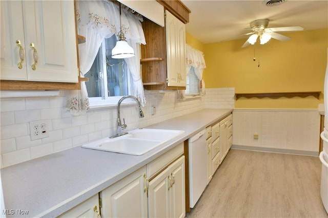 kitchen featuring ceiling fan, white dishwasher, light countertops, light wood-type flooring, and a sink