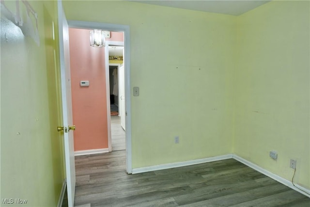 empty room with baseboards and wood finished floors