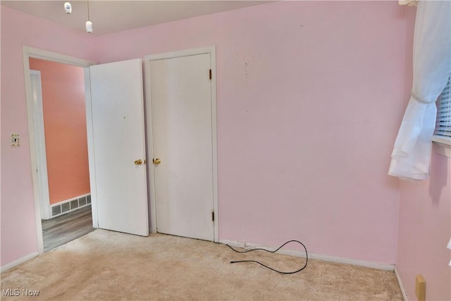 unfurnished bedroom featuring baseboards, visible vents, and carpet flooring