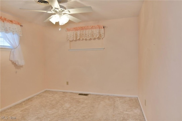 carpeted empty room featuring baseboards, visible vents, and a ceiling fan