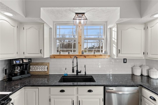 kitchen featuring tasteful backsplash, stainless steel dishwasher, white cabinetry, a sink, and a textured ceiling