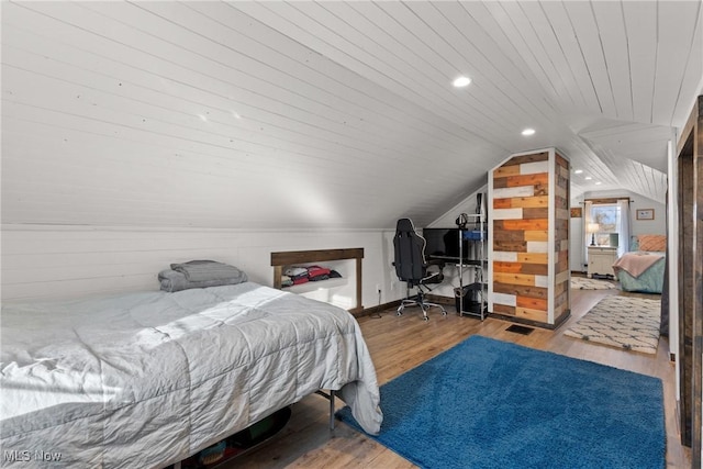 bedroom featuring wooden ceiling, vaulted ceiling, wood finished floors, and wood walls