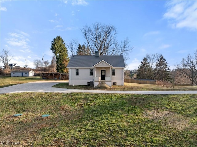 view of front of house featuring a chimney, a front lawn, and metal roof