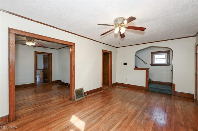 spare room featuring baseboards, visible vents, a textured ceiling, and light wood finished floors