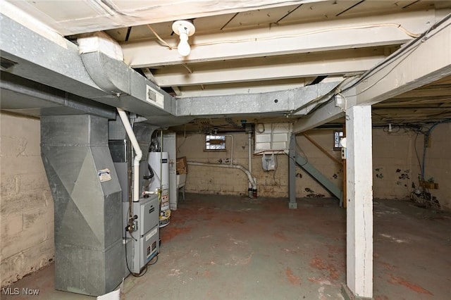 unfinished basement featuring gas water heater and heating unit