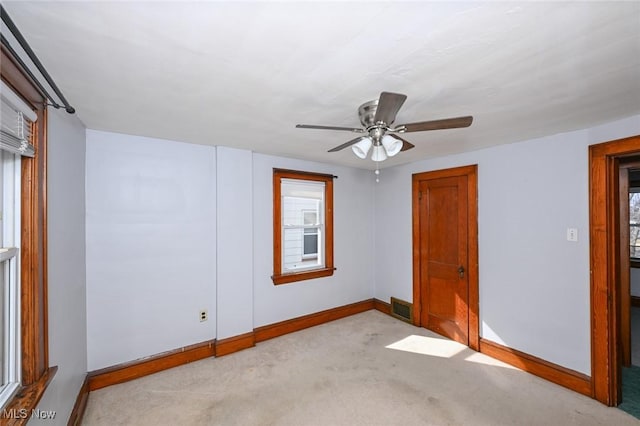 spare room featuring carpet, visible vents, plenty of natural light, and baseboards