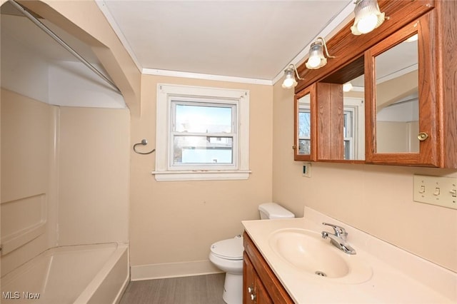 bathroom with toilet, vanity, baseboards, ornamental molding, and tub / shower combination