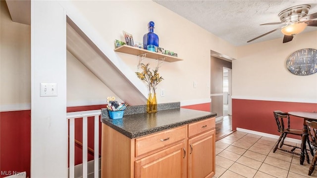 kitchen featuring a ceiling fan, dark countertops, a textured ceiling, open shelves, and light tile patterned flooring