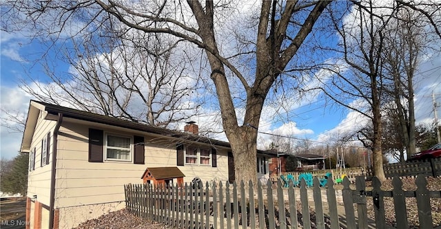 view of front facade with a chimney and a fenced front yard