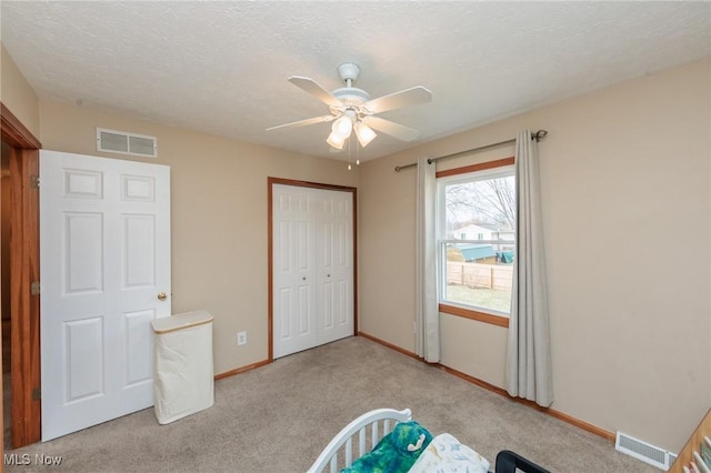 interior space with baseboards, a textured ceiling, visible vents, and a closet