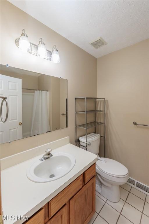 bathroom featuring toilet, tile patterned flooring, visible vents, and vanity