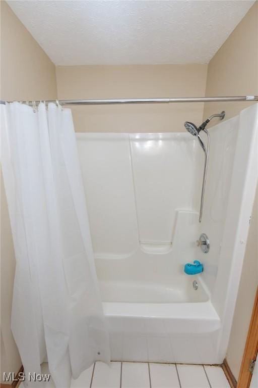 bathroom featuring shower / bath combo, a textured ceiling, and tile patterned floors