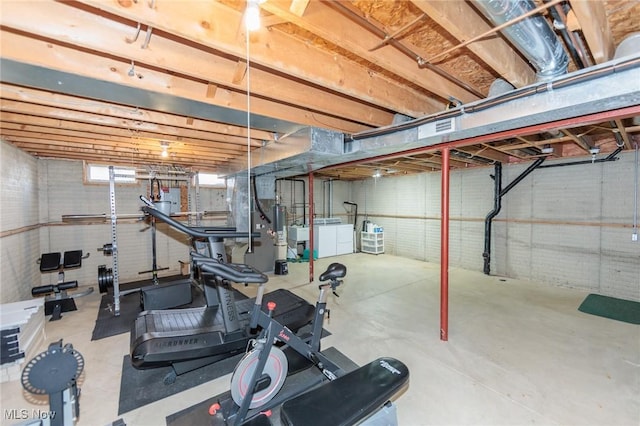 exercise area featuring brick wall and washer and clothes dryer