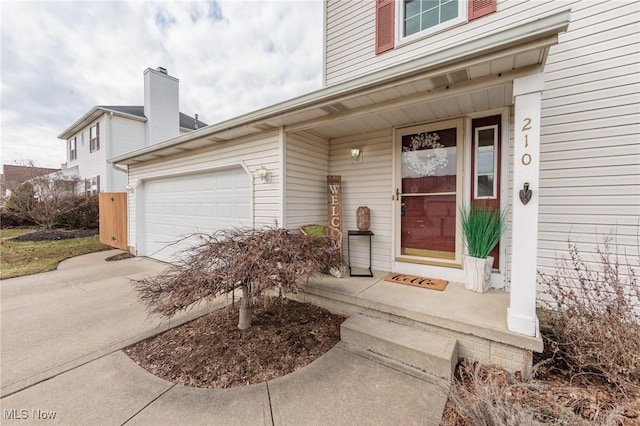 view of exterior entry featuring driveway and an attached garage