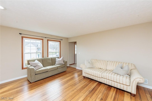 living area featuring light wood-style floors and baseboards