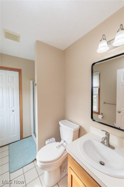 full bath with tile patterned flooring, toilet, vanity, visible vents, and a stall shower