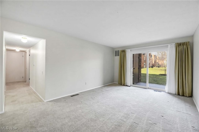 empty room with carpet, visible vents, and baseboards