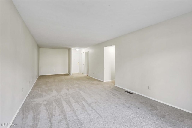 spare room with baseboards, visible vents, and carpet flooring