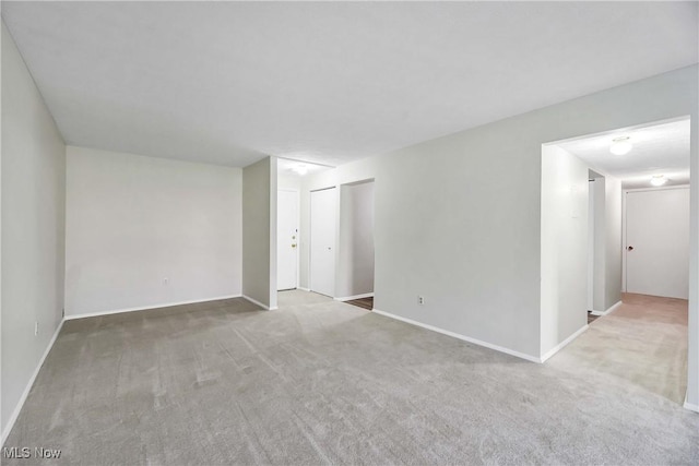 unfurnished room with carpet flooring and baseboards