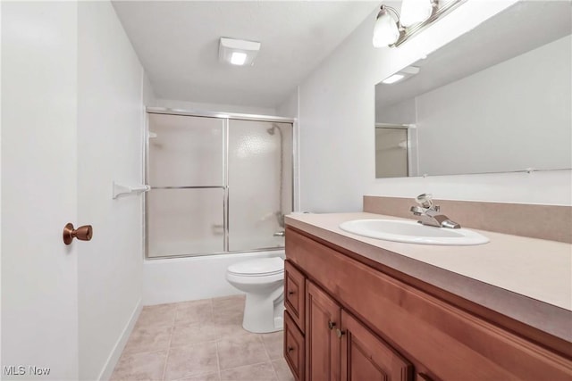 full bathroom featuring combined bath / shower with glass door, vanity, toilet, and tile patterned floors