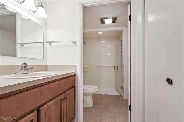 bathroom featuring tile patterned flooring, toilet, visible vents, vanity, and a shower stall