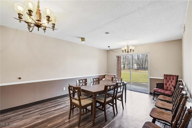 dining area with a textured ceiling, baseboards, wood finished floors, and an inviting chandelier