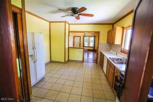 kitchen featuring light tile patterned floors, white appliances, a sink, light countertops, and ornamental molding