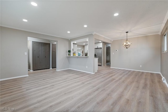 unfurnished living room featuring light wood-style floors, a notable chandelier, ornamental molding, and baseboards