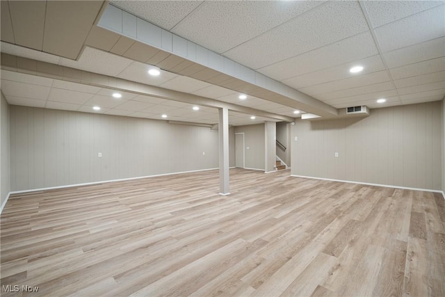 finished basement with stairway, baseboards, and wood finished floors