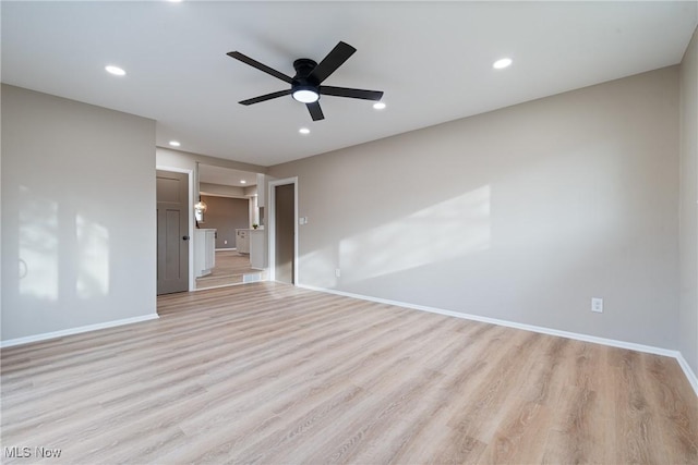 unfurnished room with baseboards, light wood-style flooring, and recessed lighting