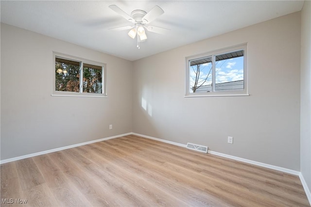 unfurnished room featuring light wood finished floors, baseboards, visible vents, and ceiling fan