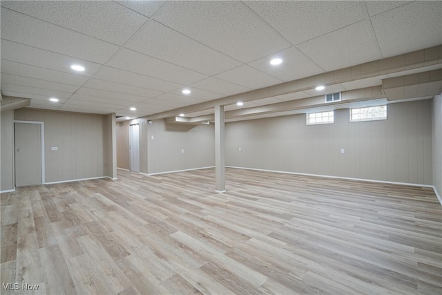 below grade area featuring wood finished floors, visible vents, and baseboards