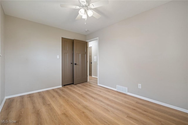 spare room featuring light wood-type flooring, baseboards, and visible vents