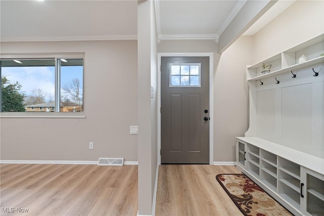 mudroom with light wood-type flooring, baseboards, visible vents, and crown molding