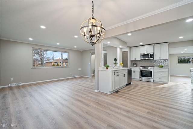 kitchen featuring visible vents, baseboards, stainless steel appliances, and decorative backsplash