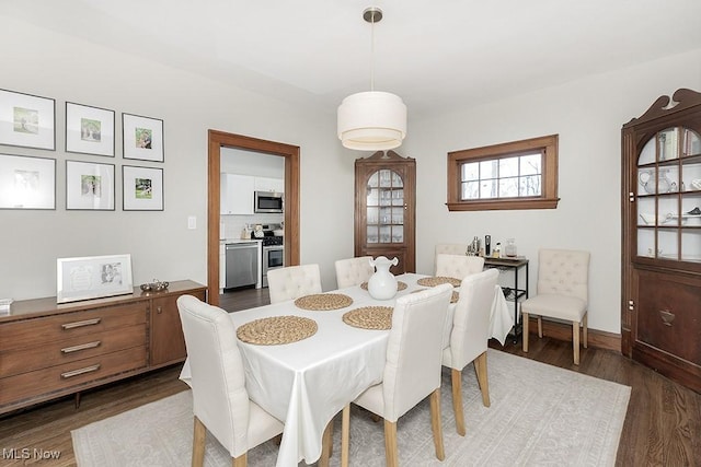 dining room with baseboards and dark wood-type flooring