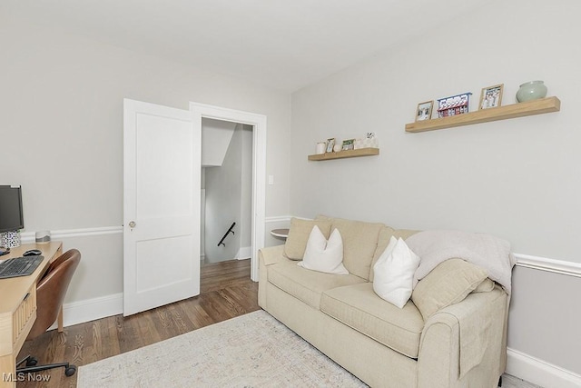 living area with baseboards and wood finished floors