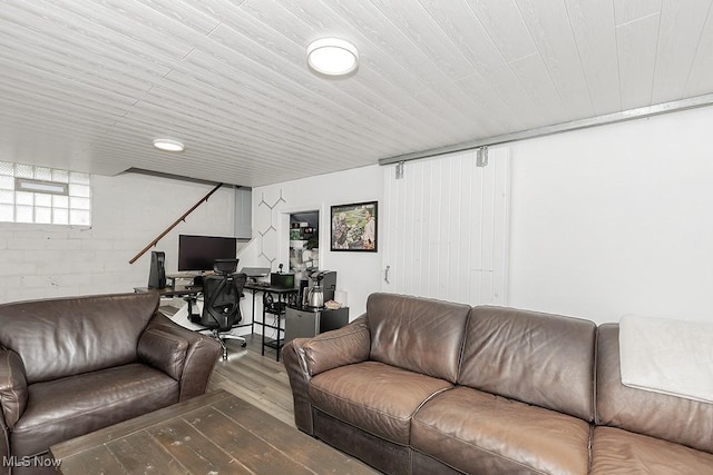 living area with concrete block wall and hardwood / wood-style floors