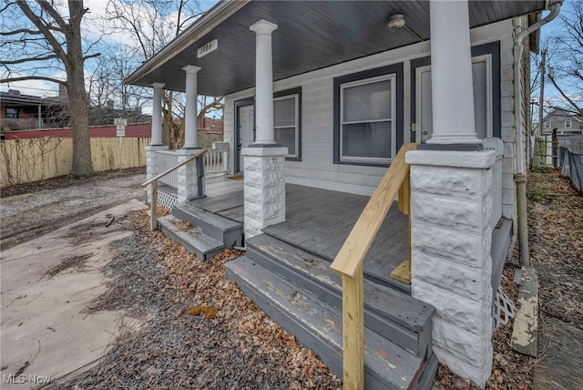 exterior space featuring covered porch and fence