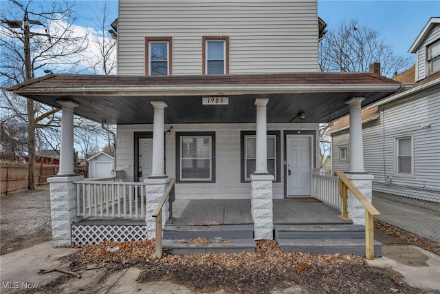 view of front of home featuring a porch, an outdoor structure, and fence