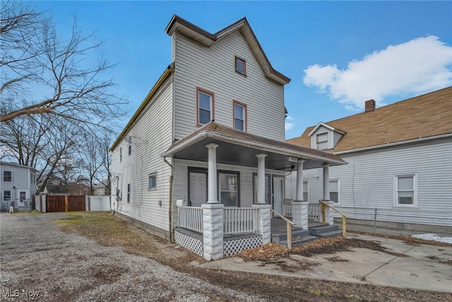 view of front facade featuring covered porch and fence