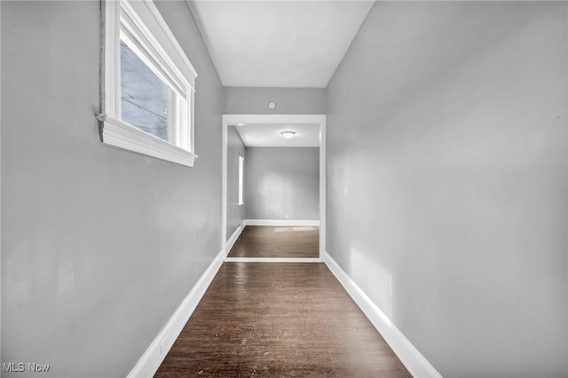 corridor featuring baseboards and wood finished floors