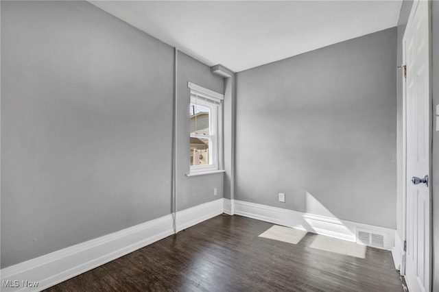 empty room with baseboards and dark wood-style flooring