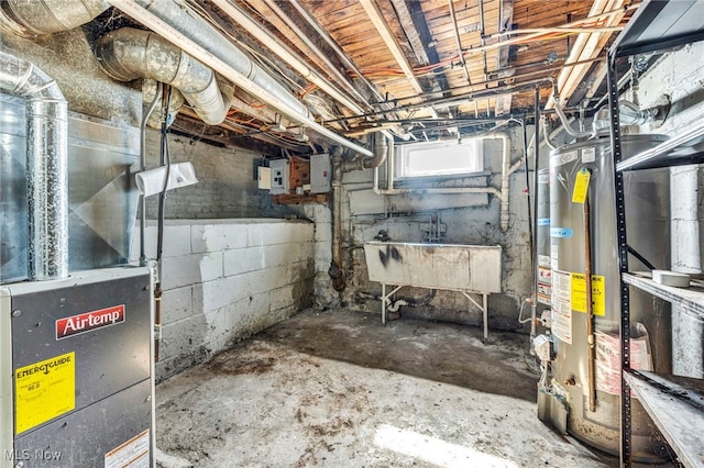 basement featuring gas water heater, a sink, and heating unit