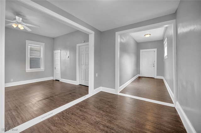 foyer entrance featuring wood finished floors, a ceiling fan, and baseboards