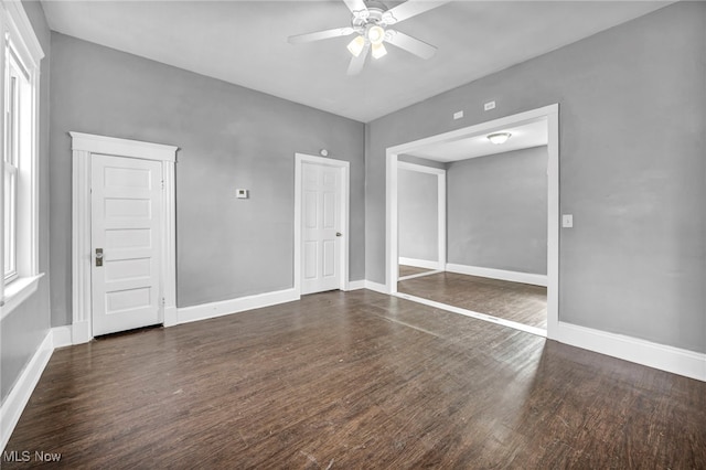 empty room featuring ceiling fan, baseboards, and wood finished floors