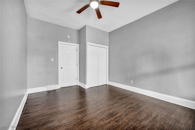 interior space with dark wood-type flooring, visible vents, baseboards, and a ceiling fan